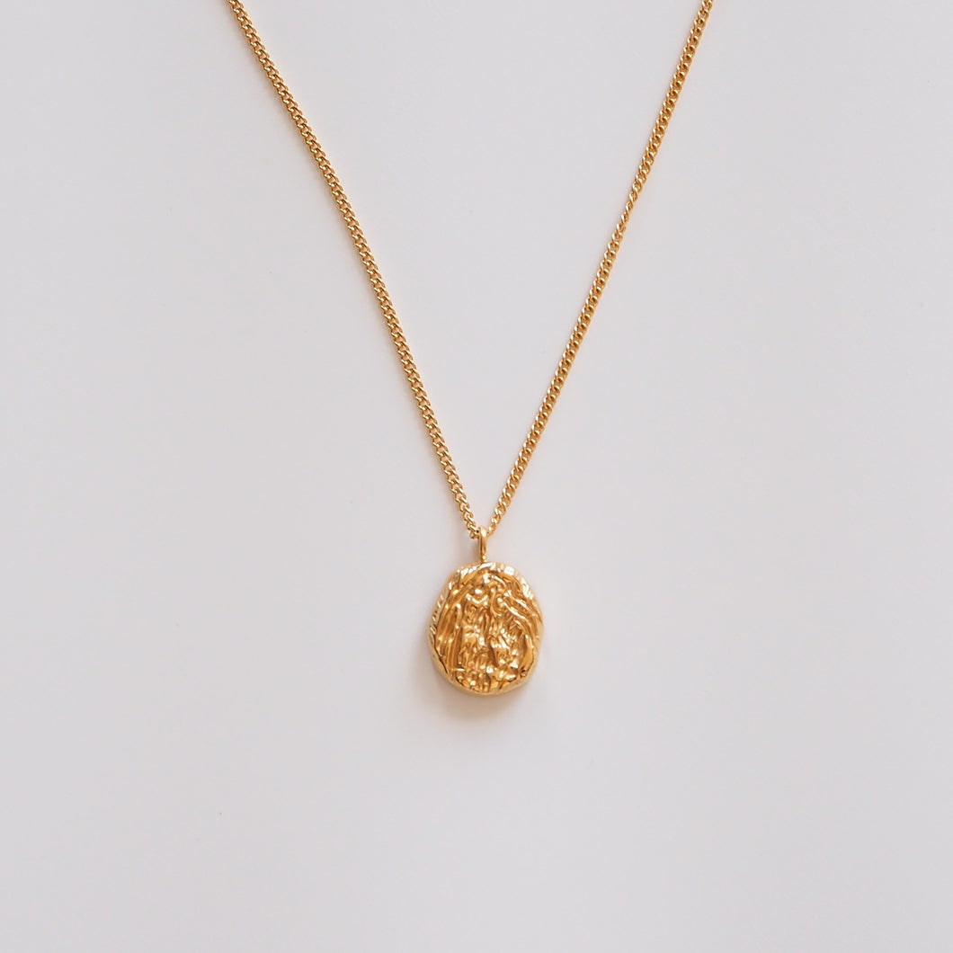 Gold necklace with uneven surface pendant